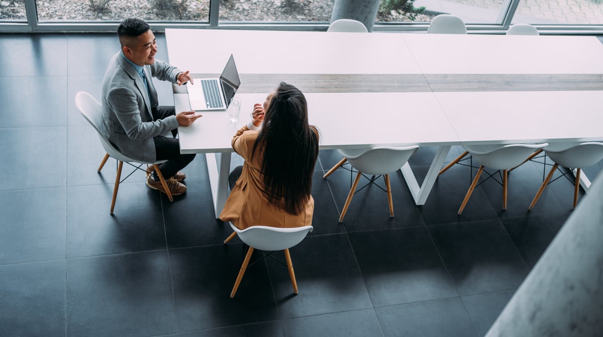 two business professionals discussing trends at a meeting