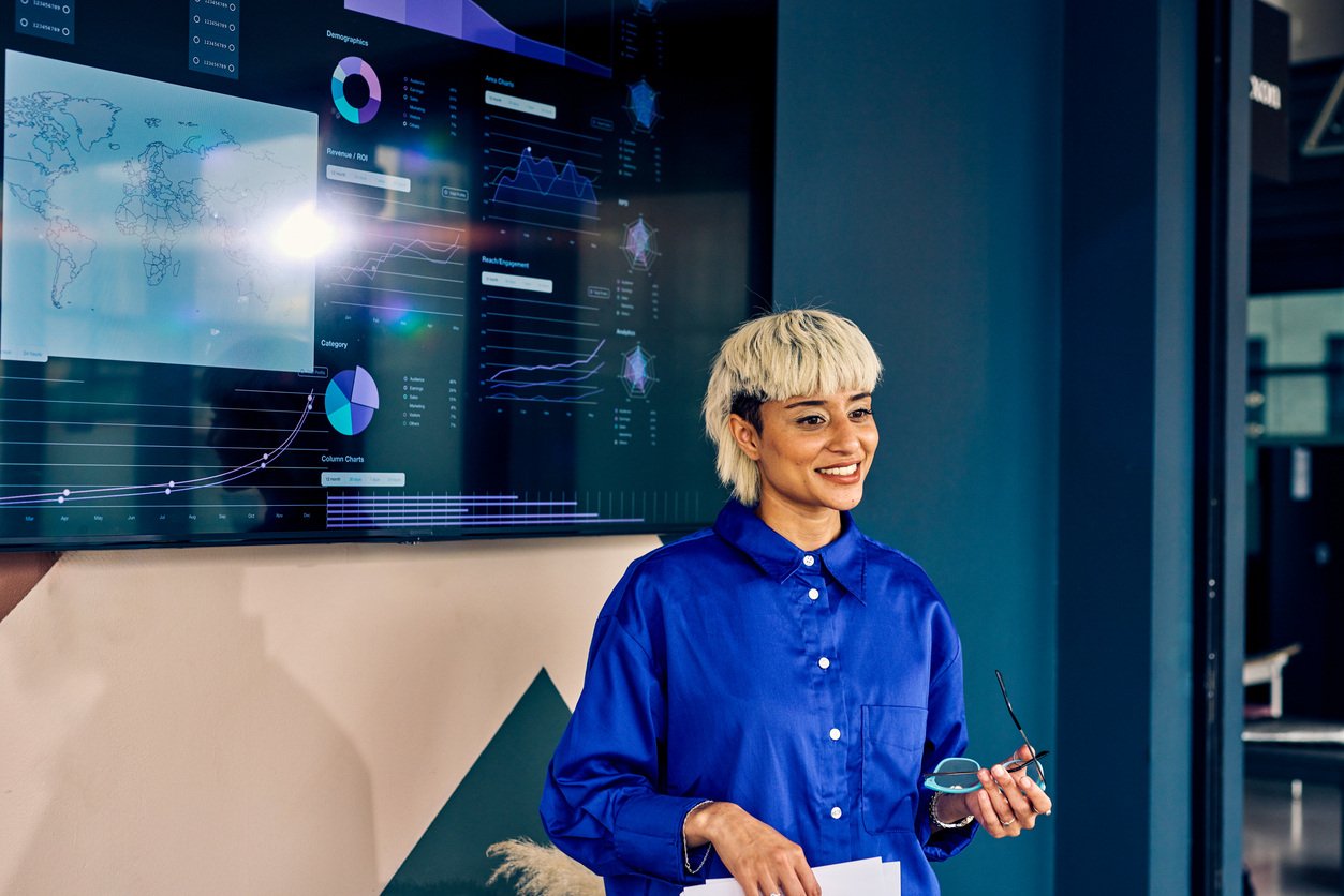 woman in blue shirt presenting analytics to business